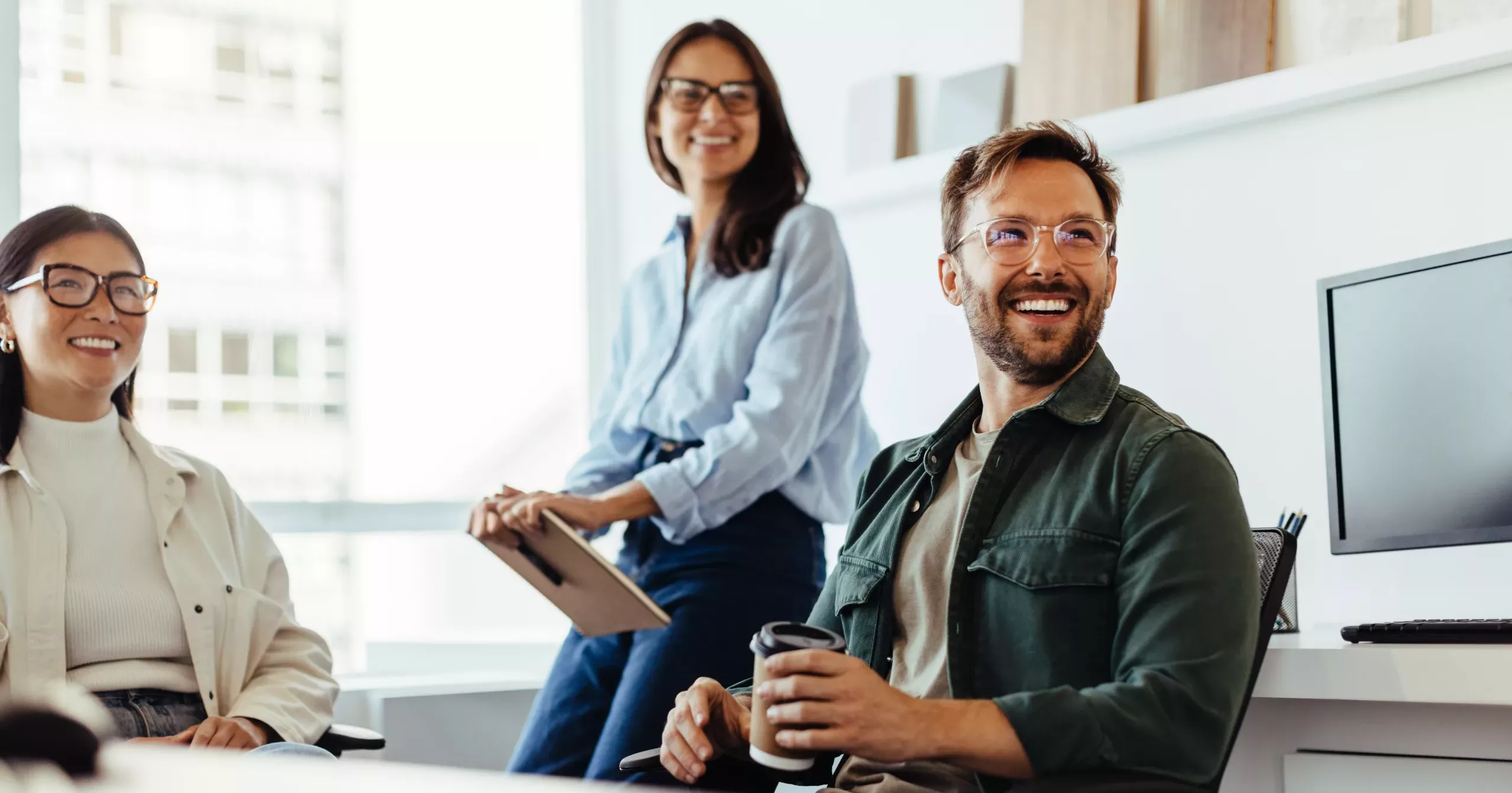 Professionals listening to a discussion in an office. Group of happy business people having a team meeting.